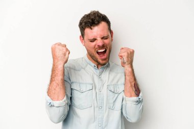 Beyaz arka planda izole edilmiş genç beyaz adam tasasız ve heyecanlı bir şekilde tezahürat yapıyor. Zafer konsepti.