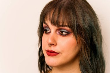 Beyaz arka planda izole edilmiş beyaz makyajlı genç bir kadın.