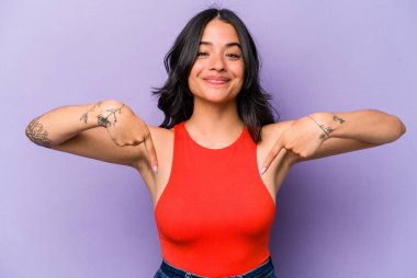 Mor arka planda izole edilmiş genç İspanyol kadın parmakları aşağıda, pozitif duygu..