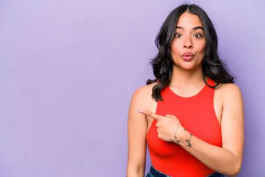 Mor arka planda izole edilmiş genç İspanyol kadın yan tarafı gösteriyor.
