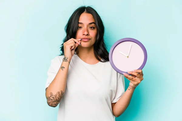 Young Hispanic Woman Holding Clock Isolated Blue Background Fingers Lips — Stok fotoğraf