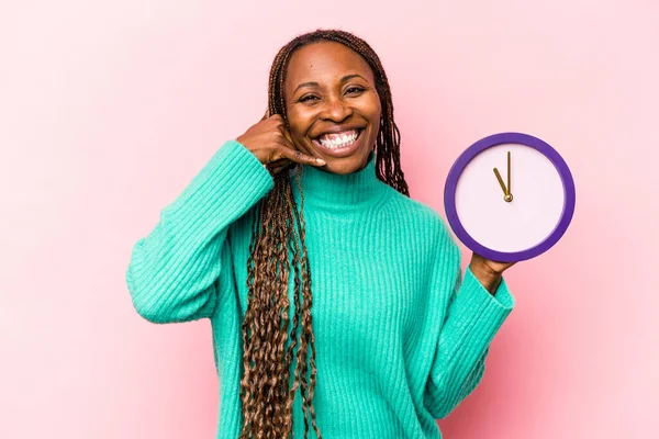 Ung Afroamerikansk Kvinna Håller Klocka Isolerad Rosa Bakgrund Visar Mobiltelefon — Stockfoto