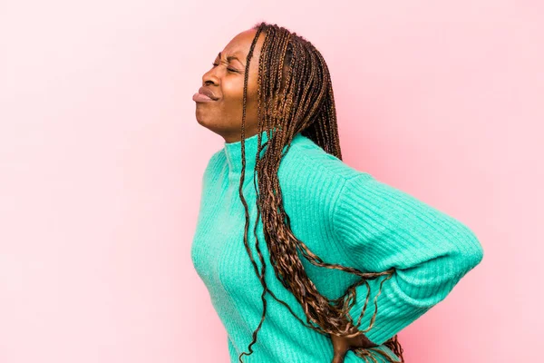 Genç Afrikalı Amerikalı kadın pembe arka planda izole edilmiş sırt ağrısı çekiyor..