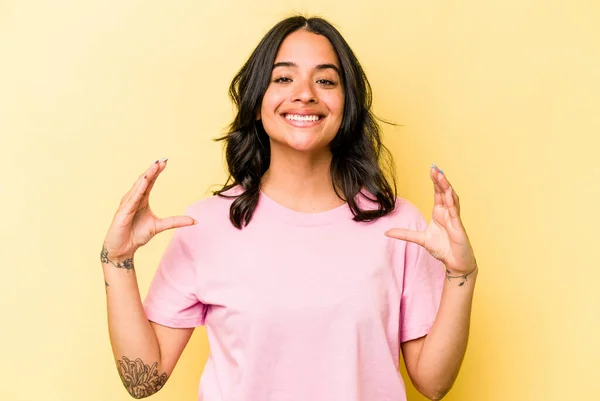 Young Hispanic Woman Isolated Yellow Background Holding Something Palms Offering — 스톡 사진