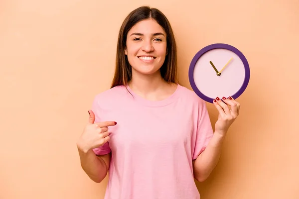 Jeune Femme Hispanique Tenant Une Horloge Isolée Sur Fond Beige — Photo