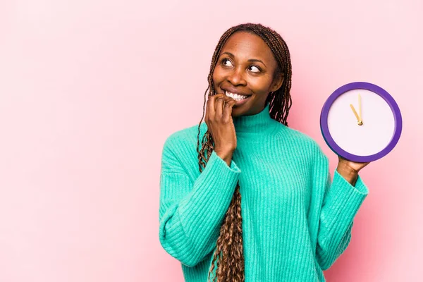 Ung Afroamerikansk Kvinna Håller Klocka Isolerad Rosa Bakgrund Avslappnad Tänka — Stockfoto