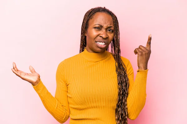 Mujer Afroamericana Joven Aislada Sobre Fondo Rosa Sosteniendo Mostrando Producto — Foto de Stock