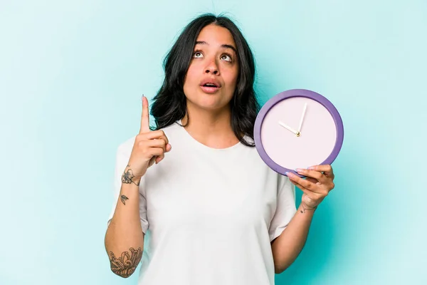 Young Hispanic Woman Holding Clock Isolated Blue Background Pointing Upside — ストック写真