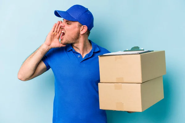 Young Caucasian Delivery Man Isolated Blue Background Shouting Holding Palm — Φωτογραφία Αρχείου