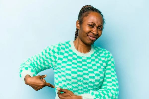 Genç Afrikalı Amerikalı kadın mavi arka planda izole edilmiş, karaciğer ağrısı, mide ağrısı var..
