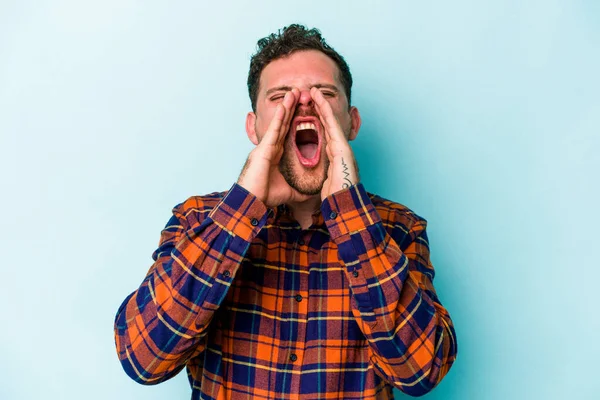 Mavi arka planda izole edilmiş beyaz bir adam heyecanlı bir şekilde bağırıyor..