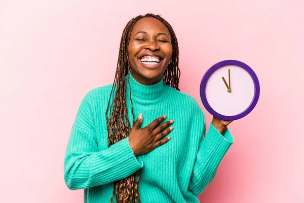 Ung Afroamerikansk Kvinna Håller Klocka Isolerad Rosa Bakgrund Skrattar Högt — Stockfoto