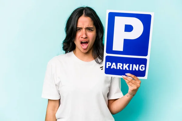 Ung Latinamerikansk Kvinna Håller Parkerings Skylt Isolerad Blå Bakgrund Skriker — Stockfoto