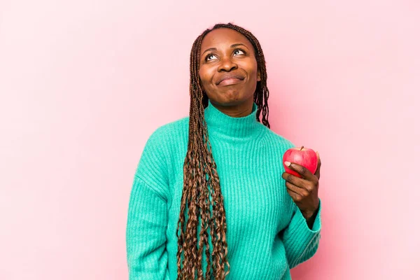 Ung Afroamerikansk Kvinna Som Håller Ett Äpple Isolerat Rosa Bakgrund — Stockfoto