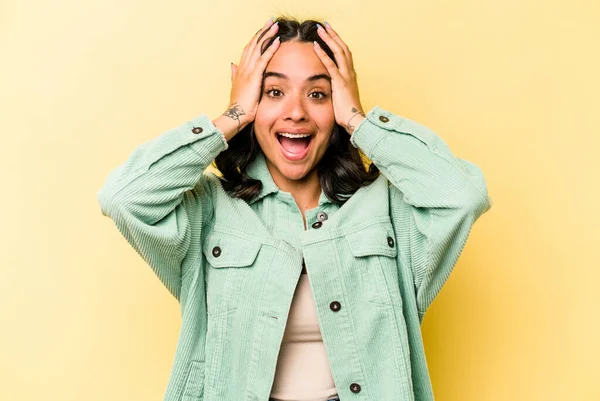 Genç İspanyol kadın sarı arka planda izole edilmiş bağırıyor, çok heyecanlı, tutkulu, bir şeyden memnun..