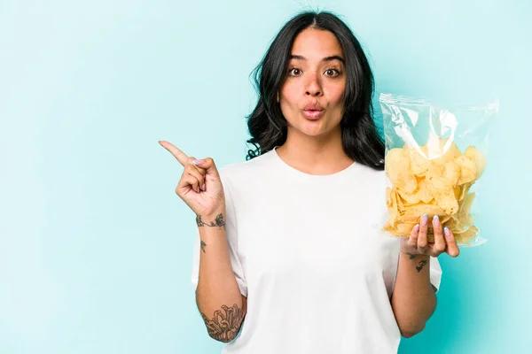 Junge Hispanische Frau Mit Einer Tüte Chips Auf Blauem Hintergrund — Stockfoto