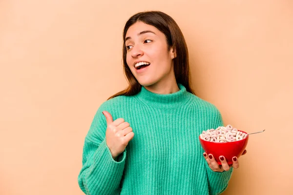 Jovem Hispânica Comendo Cereais Isolados Pontos Fundo Bege Com Dedo — Fotografia de Stock