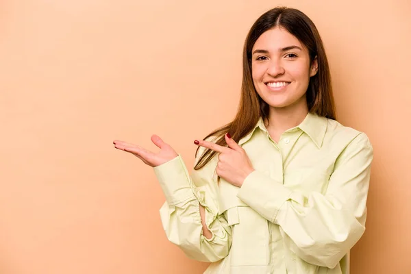 Mujer Hispana Joven Aislada Sobre Fondo Beige Emocionada Sosteniendo Espacio —  Fotos de Stock