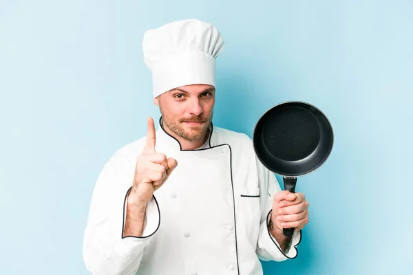 年轻的高加索厨师拿着被蓝色背景隔离的飞盘 他有一个想法 灵感的概念 — 图库照片