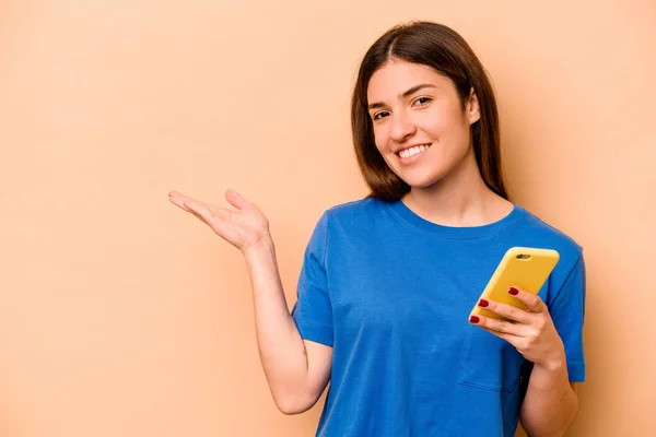 Mujer Caucásica Joven Sosteniendo Teléfono Móvil Aislado Sobre Fondo Beige —  Fotos de Stock