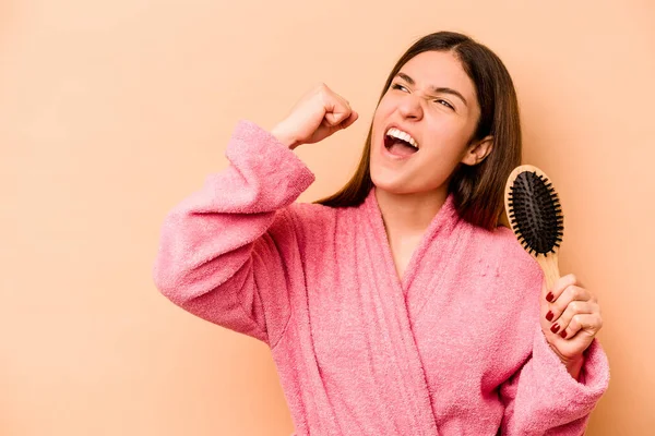 Elinde Saç Fırçası Olan Genç Spanyol Kadın Bej Arka Planda — Stok fotoğraf