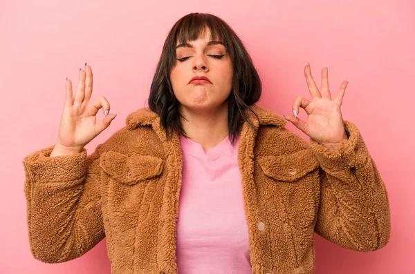 Pembe arka planda izole edilmiş genç beyaz kadın sıkı çalışma gününden sonra dinleniyor, yoga yapıyor..