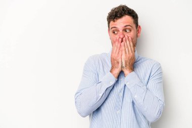 Beyaz arka planda izole edilmiş beyaz tenli genç adam ağzını eliyle kapatan bir fotokopi odasına bakıyor..