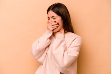 Bej arka planda izole edilmiş genç İspanyol kadın virüs veya enfeksiyon yüzünden boğaz ağrısı çekiyor..