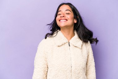 Genç İspanyol kadın mor arka planda izole edilmiş dans ediyor ve eğleniyor..