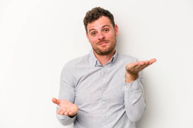 Beyaz arka planda izole genç beyaz adam kollarıyla ölçek yapar, mutlu ve kendinden emin hisseder..