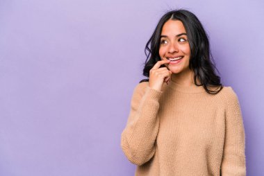 Mor arka planda izole edilmiş genç İspanyol kadın rahatlamış bir şeyin fotokopi odasına baktığını düşünüyor..