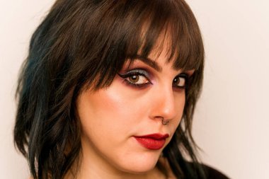 Beyaz arka planda izole edilmiş beyaz makyajlı genç bir kadın.