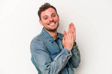 Beyaz arka planda izole olmuş genç beyaz bir adam enerjik ve rahat hissediyor, ellerini ovuşturuyor..