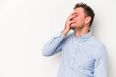 Beyaz arka planda izole olmuş genç beyaz bir adam gülüyor, kaygısız, doğal bir duygu..