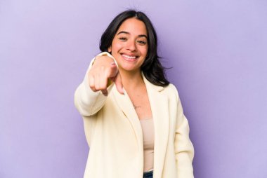 Mor arka planda izole edilmiş genç İspanyol kadın. Önü işaret eden neşeli gülümsemeler..