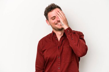 Beyaz arka planda izole olmuş genç beyaz bir adam gülüyor, kaygısız, doğal bir duygu..