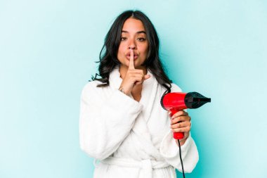 Mavi arka planda, kurutma makinesini tutan genç İspanyol kadın bir sır saklıyor ya da sessizlik istiyor..