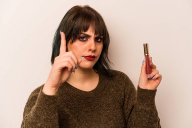 Beyaz arka planda izole edilmiş ruj tutan beyaz makyajcı genç kadının bir fikri var, ilham verici bir kavram..