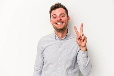 Beyaz arka planda izole edilmiş genç beyaz adam iki numarayı parmaklarıyla gösteriyor..