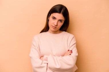 Bej arka planda izole edilmiş genç İspanyol kadın. Sıkılmış, yorgun ve dinlenmeye ihtiyacı var..