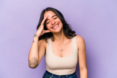 Mor arka planda izole edilmiş genç İspanyol kadın neşeli bir şekilde gülüyor. Mutluluk kavramı.