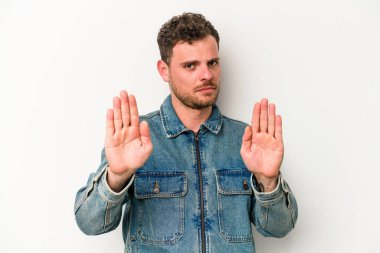 Beyaz arka planda izole edilmiş genç beyaz bir adam elini uzatmış, dur işareti göstererek seni engelliyor..