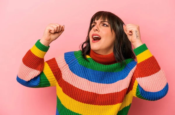 Pembe arka planda izole edilmiş beyaz bir kadın zaferden sonra yumruğunu kaldırıyor, kazanan konsept.