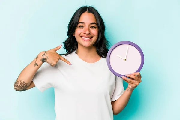 Young Hispanic Woman Holding Clock Isolated Blue Background Person Pointing — Fotografia de Stock