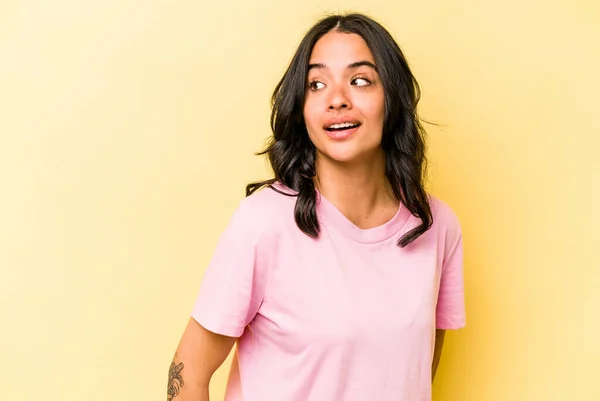 Young Hispanic Woman Isolated Yellow Background Looks Aside Smiling Cheerful — 스톡 사진