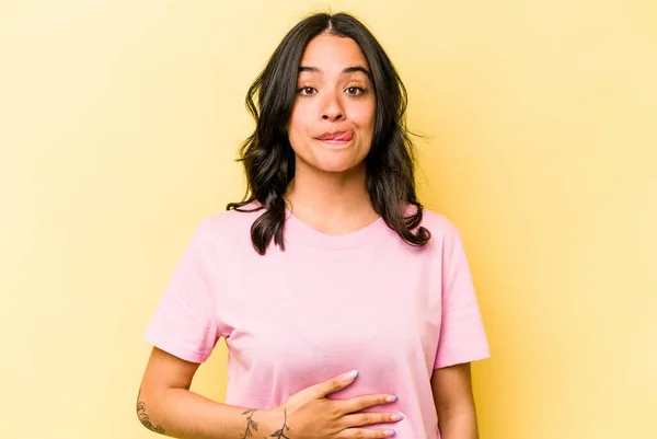 Young Hispanic Woman Isolated Yellow Background Touches Tummy Smiles Gently — Foto Stock