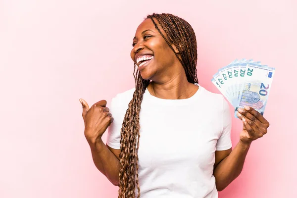 Mladá Afroameričanka Držící Bankovky Izolované Růžovém Pozadí Palcem Pryč Smějící — Stock fotografie