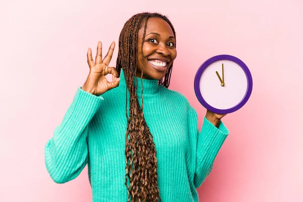 Ung Afroamerikansk Kvinna Håller Klocka Isolerad Rosa Bakgrund Glad Och — Stockfoto