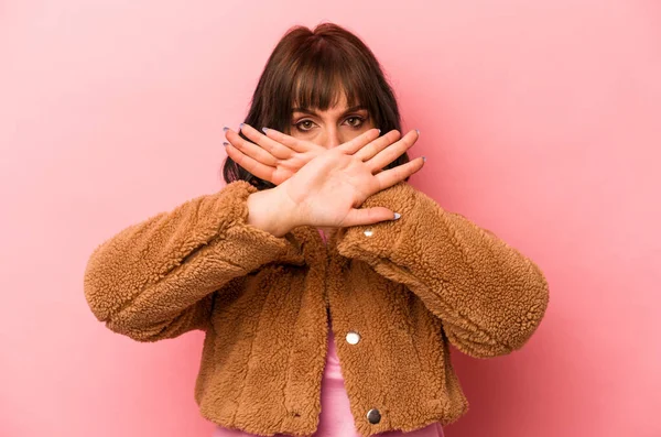 Pembe arka planda izole edilmiş beyaz bir kadın inkar jesti yapıyor.