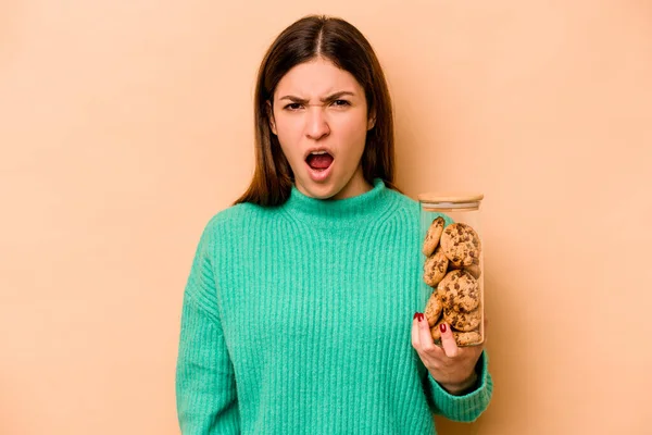 Mujer Hispana Joven Sosteniendo Galletas Tarro Aislado Sobre Fondo Beige — Foto de Stock